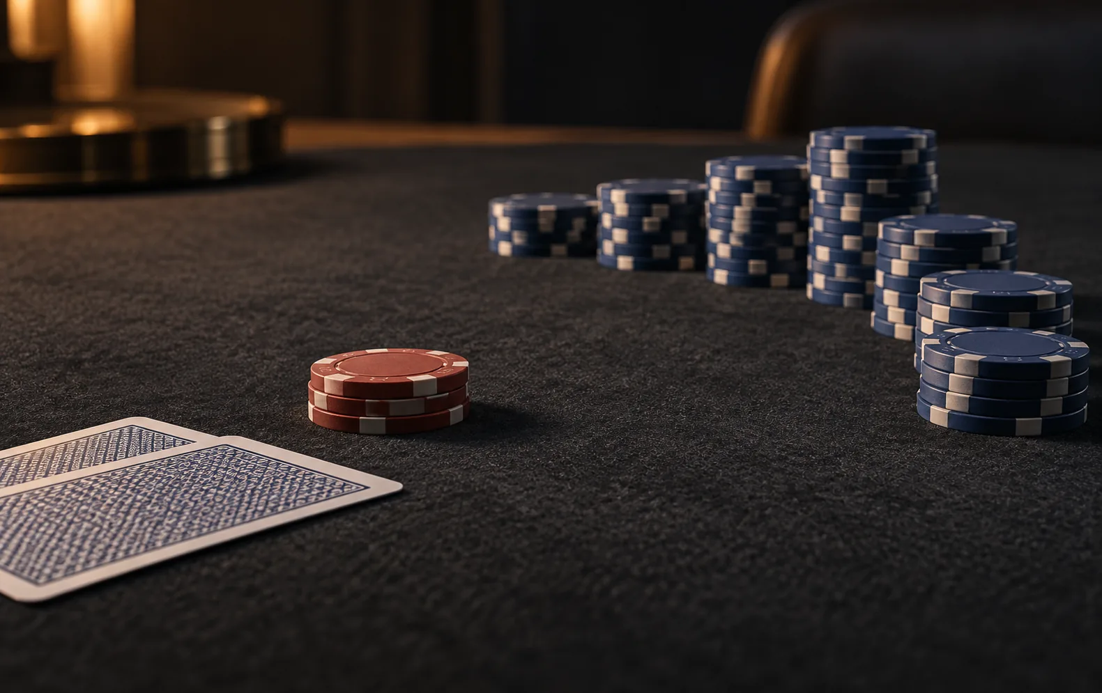 A small group of poker chips is met by a larger curved group across dark felt, suggesting a check followed by a raise